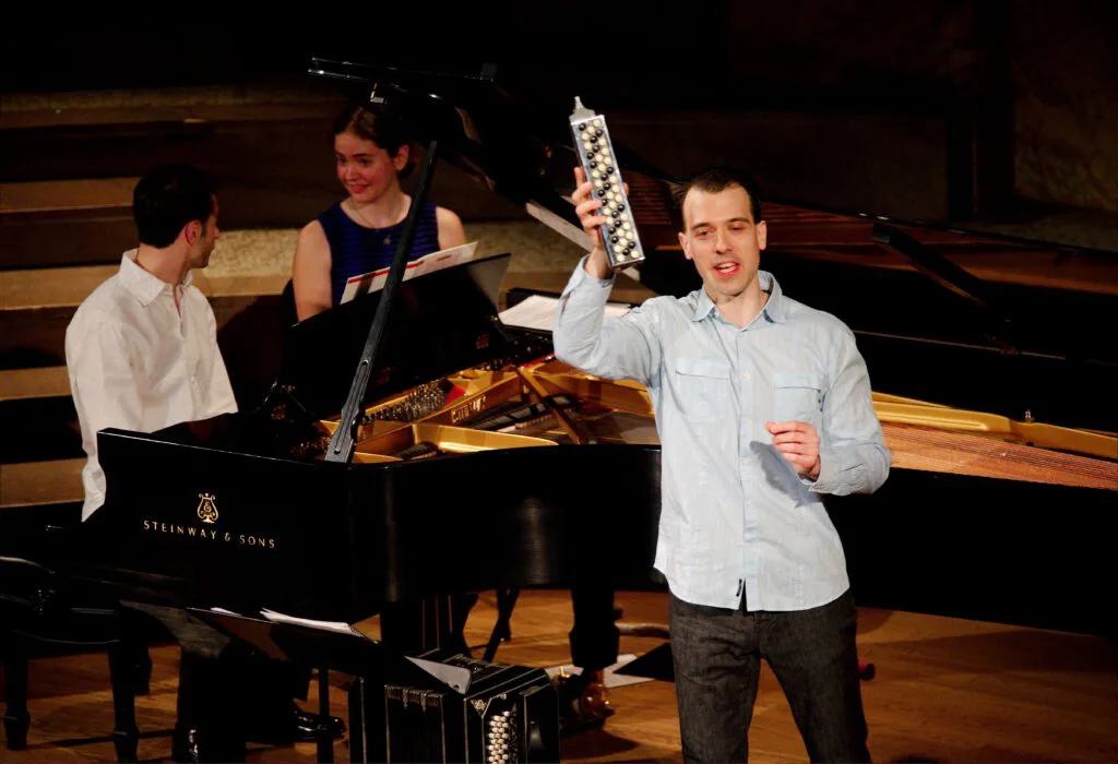 Julien Labro holding an accordina beside a piano and bandoneon