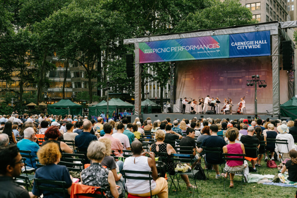 Audience and outdoor stage at the Carnegie Hall Citywide concert in Bryant Park