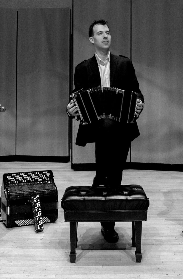 Julien Labro holding a bandoneon with an accordion and accordina beside him