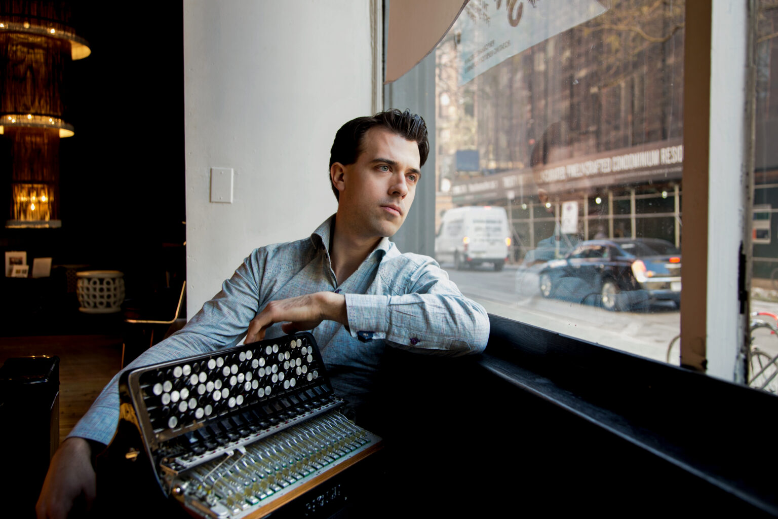 Julien Labro seated beside a window with an accordion